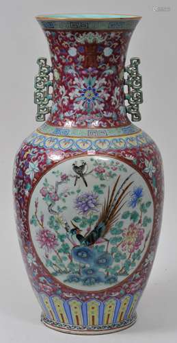 Porcelain vase. China. 19th century. Archaic scrolled handles. Famille Rose reserves of birds and flowers on a lotus scroll on magenta grounds. 22