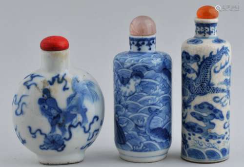 Lot of three Snuff bottles. China. 19th century. Two cylindrical, one of rounded flattened form. Underglaze blue decoration of dragons, foo dogs and mythical figures. Largest- 3-1/4