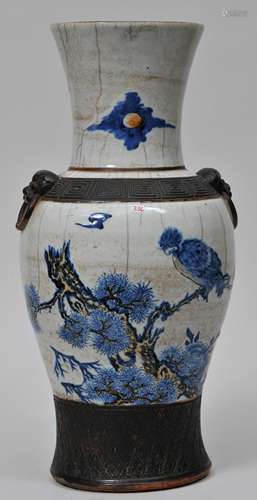 Porcelain vase. China. Late 19th to early 20th century. Underglaze blue and red decoration of birds and flowers on a crackled ground. Brown underglazed borders. Lion mask handles. 18