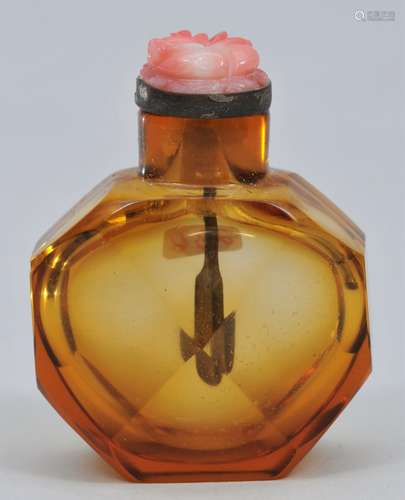 Snuff bottle. China. 19th century. Faceted amber glass. Carved coral glass stopper. 1-1/2