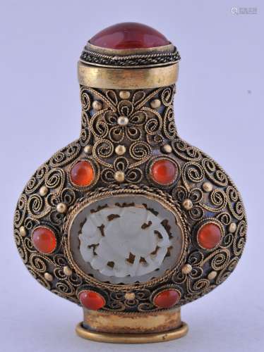Lot of three snuff bottles. China. 20th century. To include: a gilt silver bottle inset with white jade, carnelian and decorated filigree. A Ku Yueh Hsuan bottle with a Ch'ien Lung mark and a 