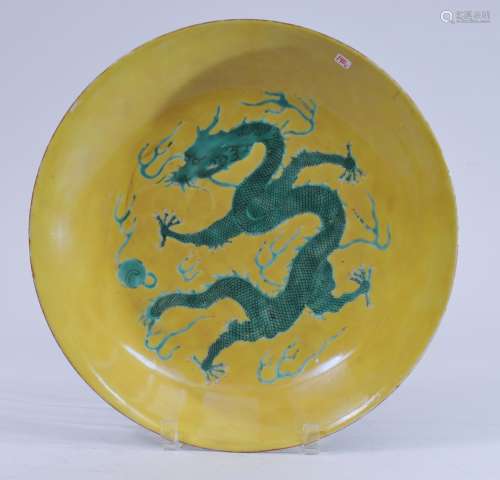 Porcelain shallow bowl. China. Kuang Hsu mark (1875-1908) and probably of the period. Decoration of a green dragon with a pearl on a yellow ground. 12-3/4