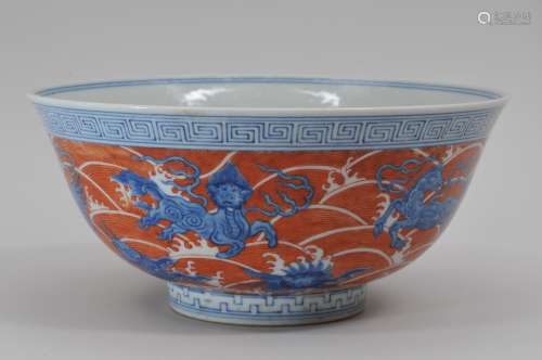 Porcelain bowl. China. 20th century. Underglaze blue mythical animals on a iron red wave ground. Ch'ien Lung mark on the base. 8-1/4