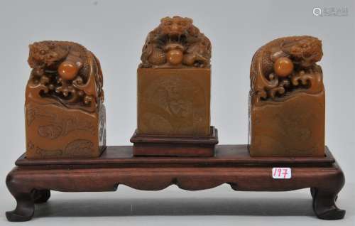 Three soapstone seals. China. 1930's. Yellow wax stone. Dragon finials. Seals intact. Fitted wooden stand. Each about 3-1/2