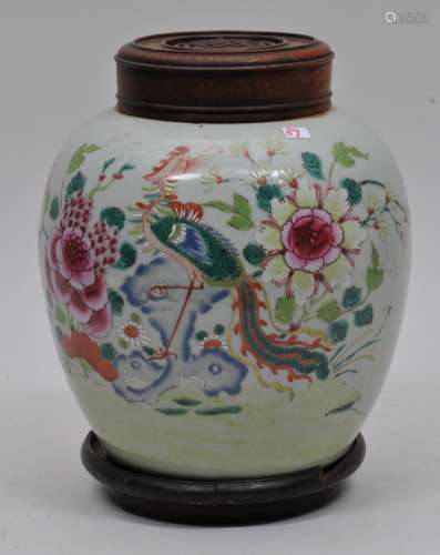 Porcelain jar. China. 19th century. Globular form. Decoration of a phoenix and flowers. Carved wooden cover and stand. 7-1/2