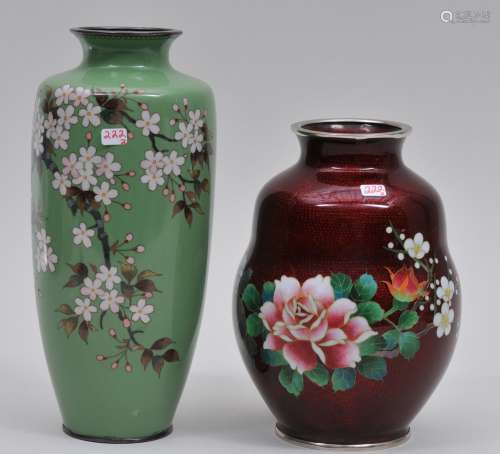 Lot of two Cloisonne vases. Japan. Early to mid 20th century. One with cherry blossoms on a grey-green ground. The other with roses on a pigeon blood ground. 8-3/4
