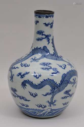 Porcelain vase. China. 19th century. Bottle form. Underglaze blue decoration of dragons and clouds. Crack to the neck. 15