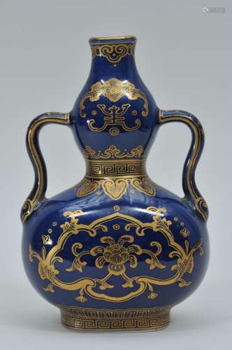 Porcelain vase. China. 20th century. Double gourd form with ju-i handles. Dark blue ground with gilt decoration. 7