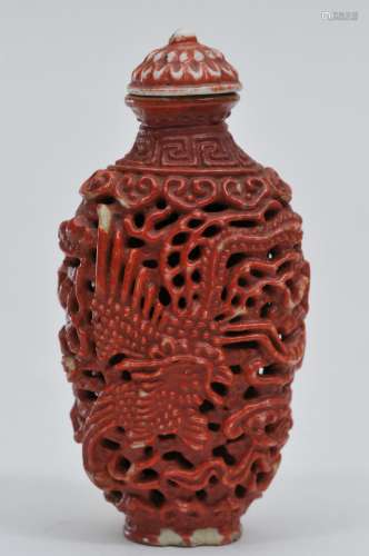Snuff bottle. China. 19th century. Carved porcelain. Design of dragons and clouds. Cinnabar color. Chrysanthemum stopper. 2-7/8