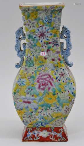 Porcelain vase. Kuang Hsu mark and probably of the period. Early 20th  century. Fang Hu form with a stylized chih lung handles. Mille fleur decoration on a yellow ground. 11-1/2