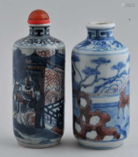 Lot of two Snuff bottles. China. 19th century. Cylindrical form. Underglaze blue and red decoration of cames and an historical scene. One with a Yung Cheng mark. Each about 3-1/2