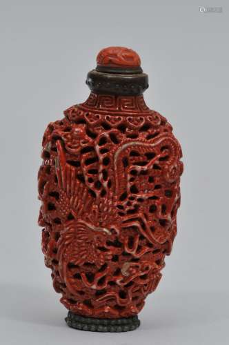 Snuff bottle. China. 19th century. Carved porcelain. Design of dragons and clouds. Cinnabar color. Silver mounted foot and coral cover.  3