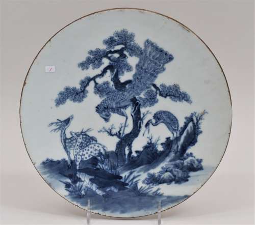 Round porcelain plaque. China. 19th century. Underglaze blue decoration of a pair of deer, a peacock and a crane with a pini tree and foliage. 10-3/4