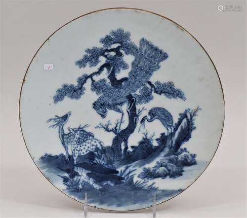 Round porcelain plaque. China. 19th century. Underglaze blue decoration of a pair of deer, a peacock and a crane with a pini tree and foliage. 10-3/4