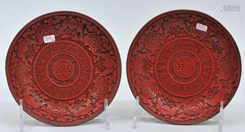 Pair of Cinnebar saucer dishes. China. 18th/19th century. Surfaces carved with bats, flowers and stylized shou characters. 5