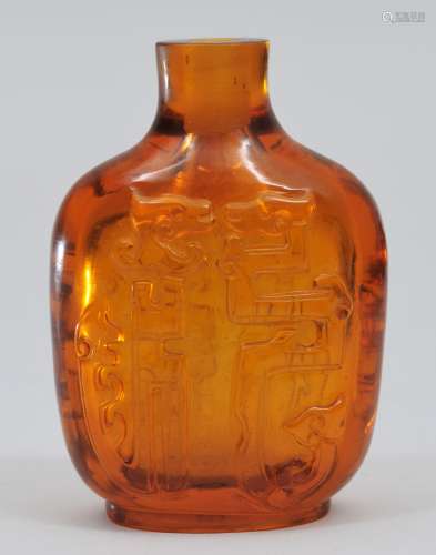 Snuff bottle. China. 19th century. Amber glass carved with archaic style facing dragons. Well hollowed. 2-3/4