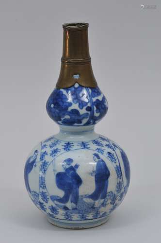 Porcelain vase. China. Probably Ming period (1368-1644). Double gourd form. Underglaze blue decoration of reserves of the Immortals and a ground of Shou characters. Brass mounted neck. 8