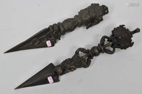 Two bronze ritual knives. Tibet. 19th century. Phurbas decorated with makala figures and the heads of tantric deities. 11