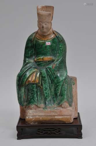 Stoneware figure. China. Ming period (1368-1644). San Tsai glazed seated figure in official robes. Green and yellow colour. 12-1/4