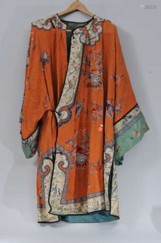 Woman's robe. China. Circa 1920. Orange ground with baskets of flowers in embroidery. Moth damage, stains, fading. 23