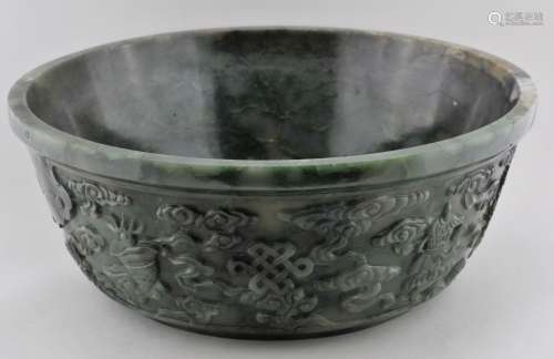 Jade bowl. China. 18th century. Highly translucent pale green stone with forest green veining.  Carving of the Eight Precious Emblems and clouds. 8-3/4