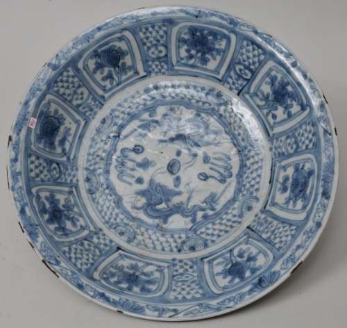 Porcelain charger. China. 17th century Transitional ware. Swatow ware. Kraak style underglaze blue  decoration of dragon and floral reserves on a brocade ground. 15