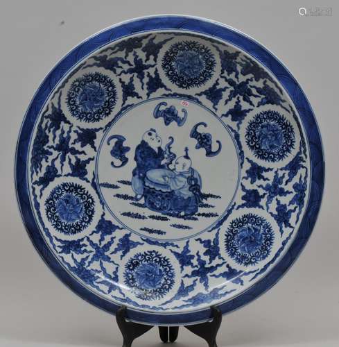 Porcelain charger. China. 20th century. Underglaze blue decoration of children playing. Borders of flowers and clouds. Exterior with dragons. Yung Cheng mark. 19-1/2