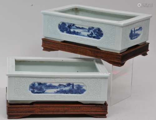 Pair of planters. China. 19th century. Rectangular shape. Surface carved with a thunder meander pattern. Inset reserves of underglaze blue landscapes. Impressed Yung Cheng mark on the base. 9-1/2