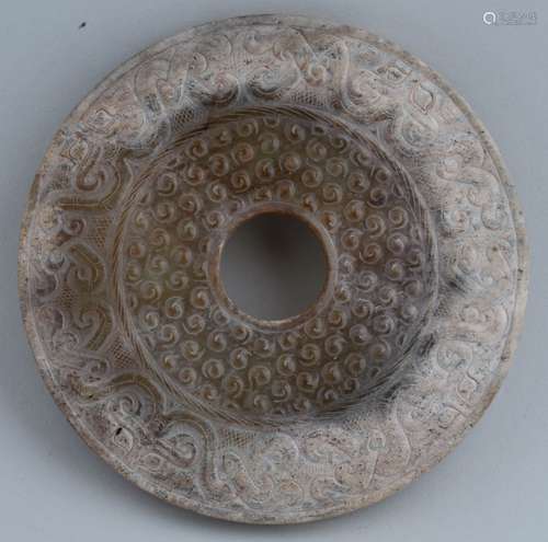 Ritual Jade. China. Han style. Pi of much calcified brown stone. Carving of mythical animal scrolling and comma marks. 4