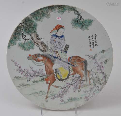 Circular porcelain plaque. China. Republic Period, circa 1930. Famille Rose enamel decoration of a female warrior on horseback with an inscription. 11-1/2