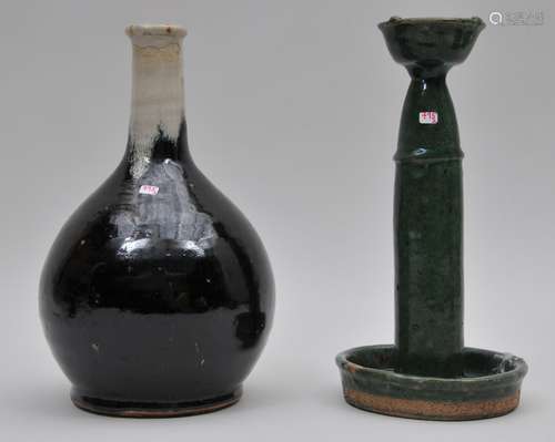 Lot of two ceramics. To include: A green glaze 19th century Chinese lamp stand and an 18th century Karatsu sake bottle with a black and white glaze. Both 11