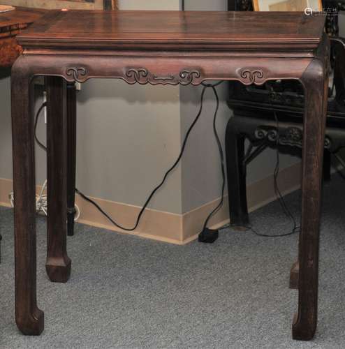 Rosewood occasional table. China. 19th century. Elephant trunk feet. Aprons carved with archaic scrolling. 33