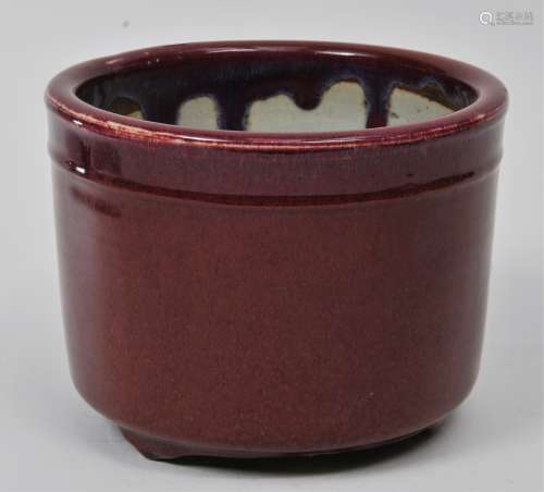 Porcelain planter. China. 19th century. Cylindrical form. Deep purple red Lang Yao glaze. Chip to one foot. 8