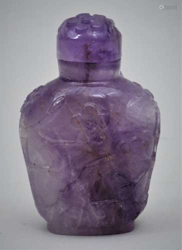 Snuff bottle. China. 19th  century. Amethyst. Surface carved with birds and flowers. Matching stopper. 2-1/2