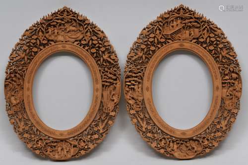 Pair of sandalwood frames. China. Mid to late 19th century. Oval shape. Carved and pierced with birds and flowers. One with reserves of agricultural scenes; the other with fishing scenes. 16