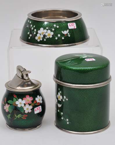 Cloisonné smoking set. Japan. Circa 1950. Three pieces. To include; A cigarette box, ashtray and lighter. Green bas taille work with standard cloisonné cherry blossoms. Signed Nekka.