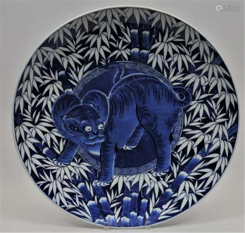 Porcelain charger. Japan. 19th century. Arita ware. Underglaze blue decoration of a tiger and bamboo. 23