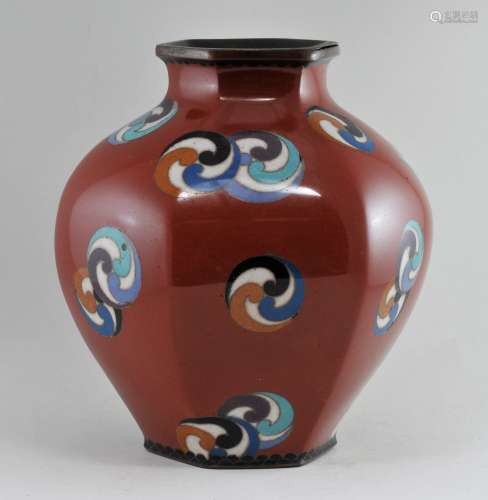 Cloisonné vase. Japan. Meiji period. (1868-1912). Hexagonal shaped. Decoration of polychromed mons on a brick red ground. 4-1/2