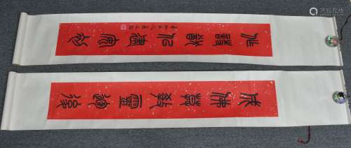 Pair of hanging scrolls. China. 20th century. Calligraphy in Li Shu script on silver flecked red paper. 50-1/2