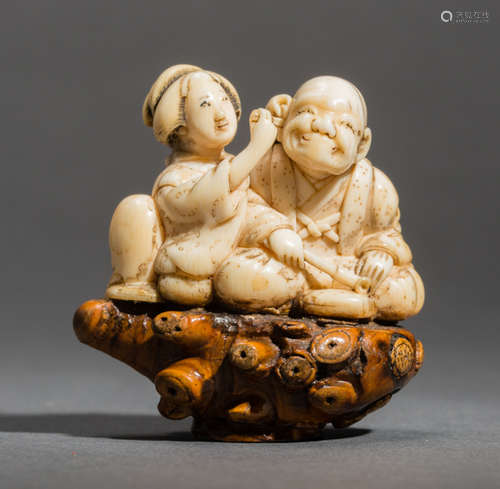 AN IVORY NETSUKE OKIMONO OF A MAN WITH BIJIN