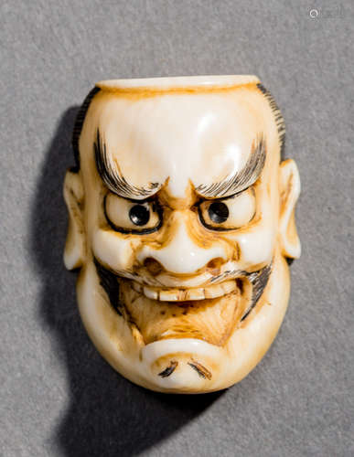 AN IVORY NETSUKE BY KOICHI OF A TOBIDE MASK