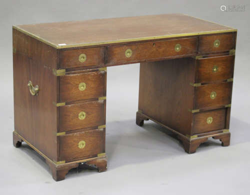A late 20th century reproduction mahogany campaign style twin pedestal desk with brass mounts