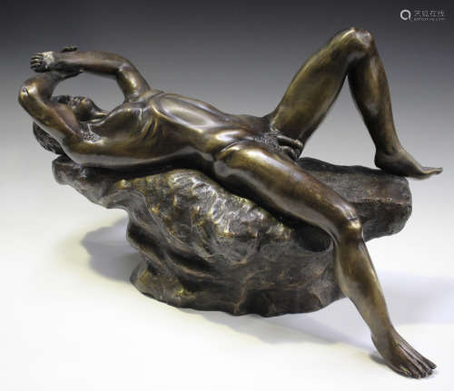 A mid-20th century brown patinated cast bronze nude figure of a recumbent man