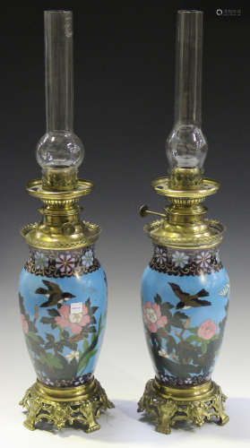 A pair of late 19th century Japanese cloisonné and French gilt metal mounted table oil lamps with ovoid bodies and pierced foliate feet