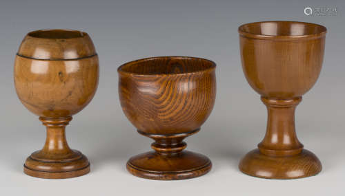 A group of three turned treen goblets