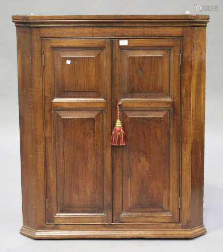 An 18th century elm and oak hanging corner cabinet