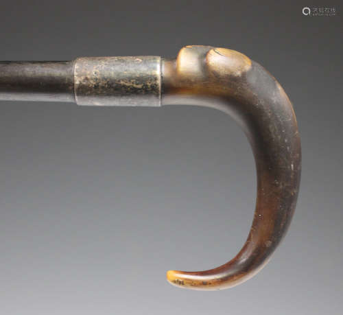 A late 19th/early 20th century rhino horn handled walking stick with a monogrammed metal collar and ebony shaft