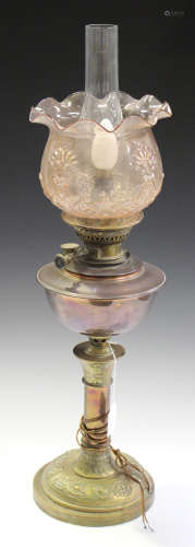 A late 19th/early 20th century copper and brass table oil lamp with a moulded pink glass shade