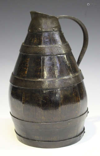 A 19th century oak coopered and iron mounted cider jug of ovoid form with loop handle