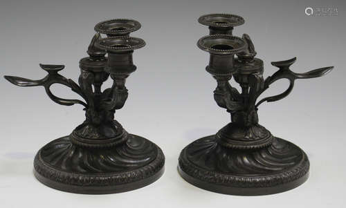 A pair of Regency brown patinated cast bronze twin light desk candlesticks